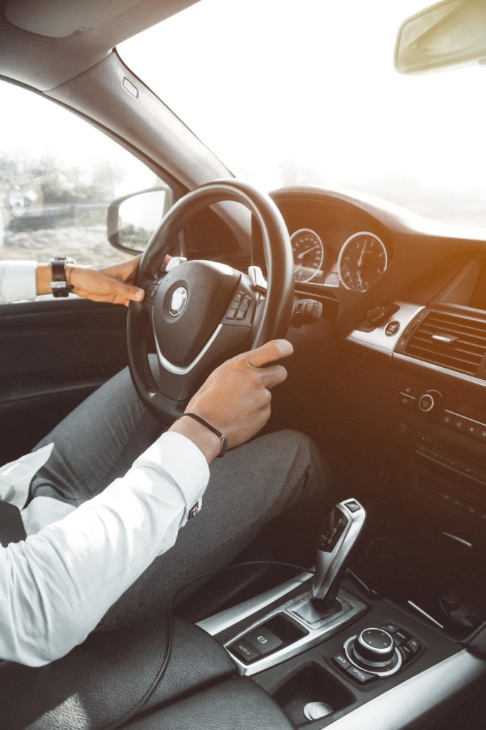man in white dress shirt holding steering wheel 804130